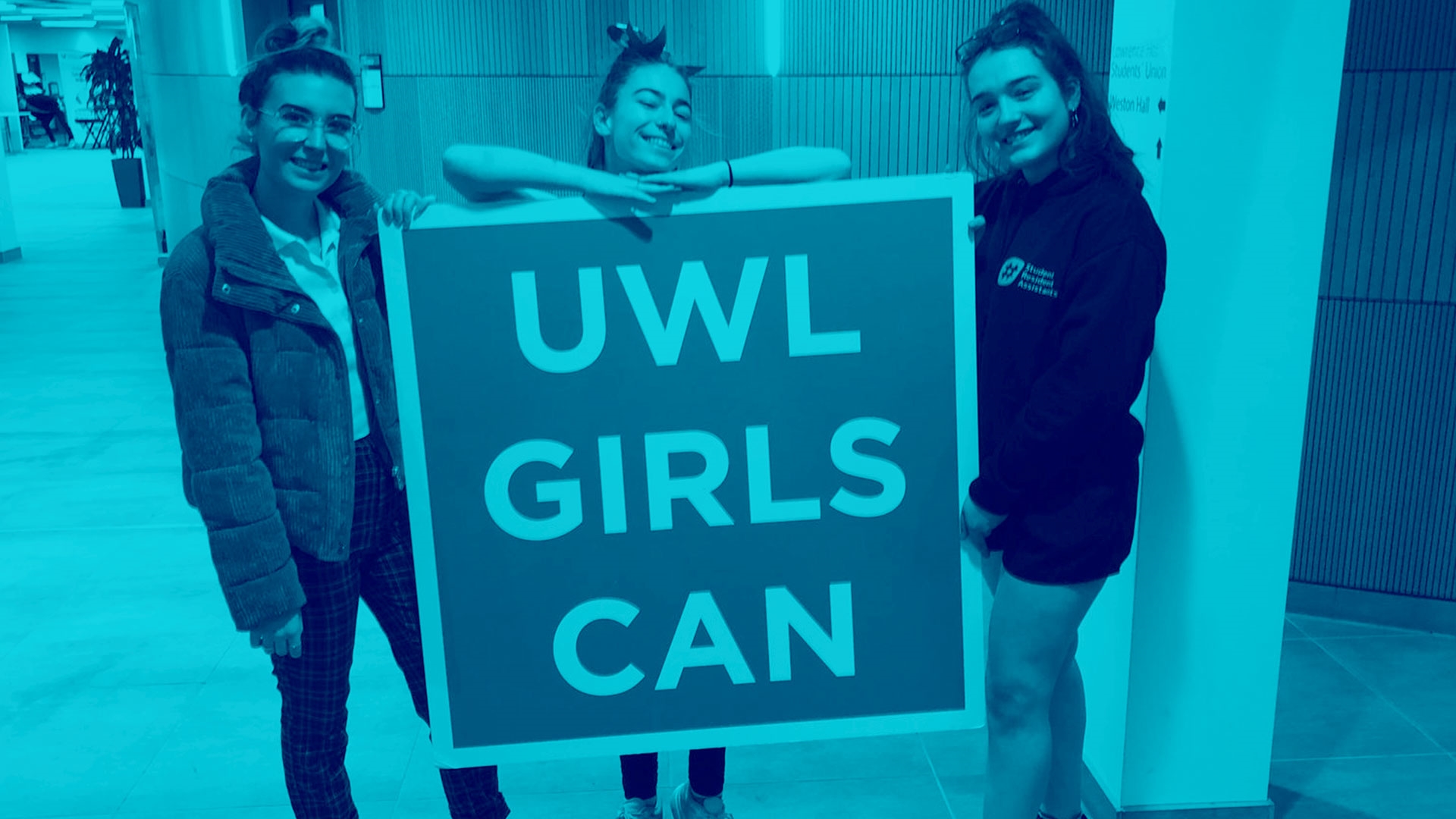 Student Group holding UWL Girls Can sign