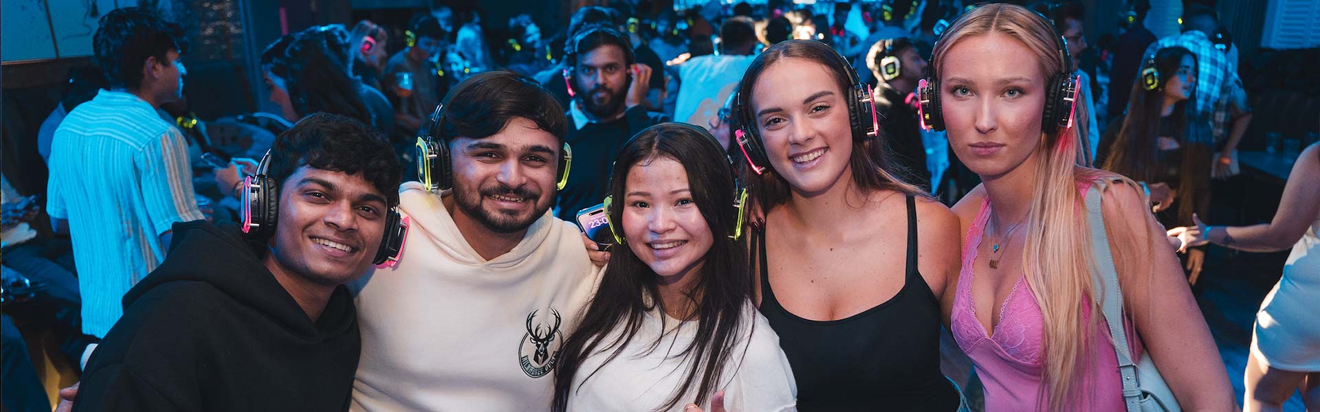 Students posing in front of the camera at a silent disco event