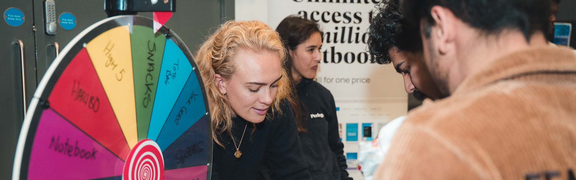 Students queuing to spin a wheel of prizes at an event