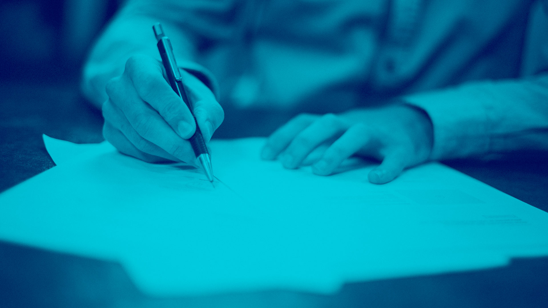 Male writing on a piece of paper