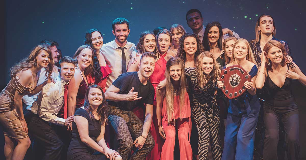 Students attending an awards event and posing with their trophies