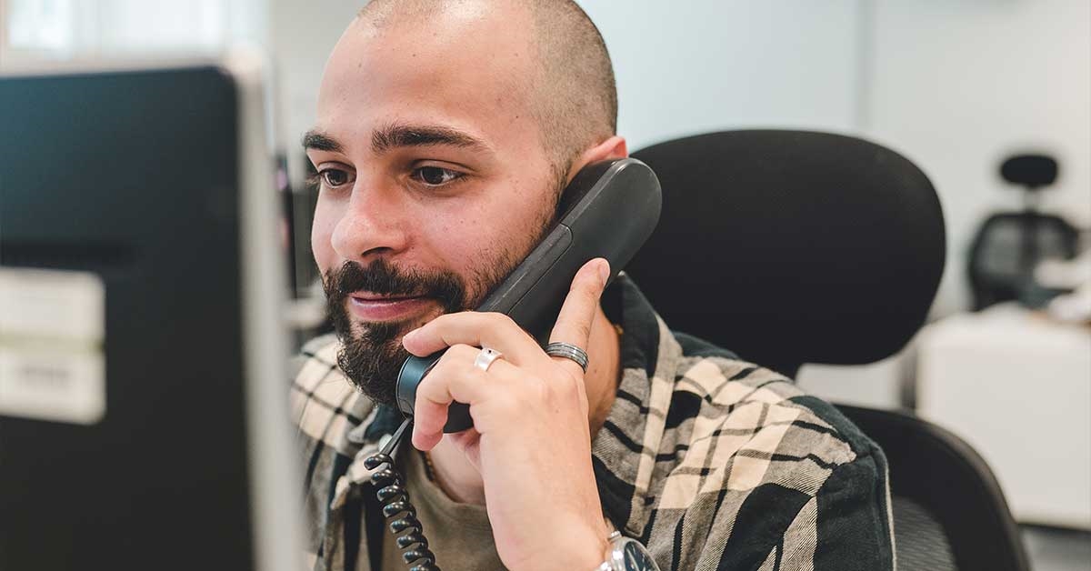 A Sabbatical Officer sat at their desk on the phone